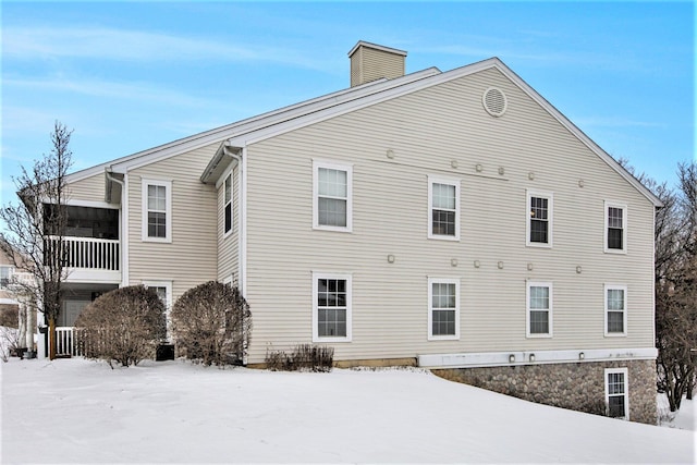 snow covered property featuring a chimney