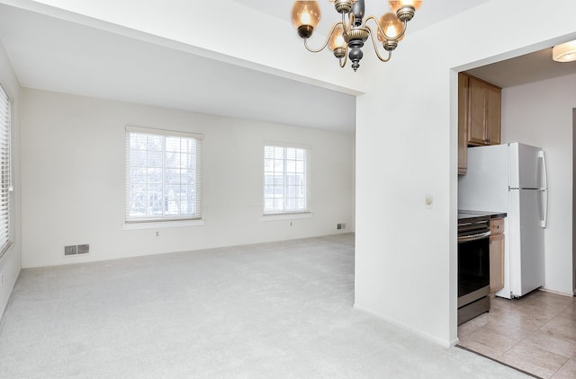 interior space with a notable chandelier, light carpet, visible vents, open floor plan, and stainless steel electric range oven