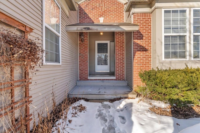 doorway to property featuring brick siding