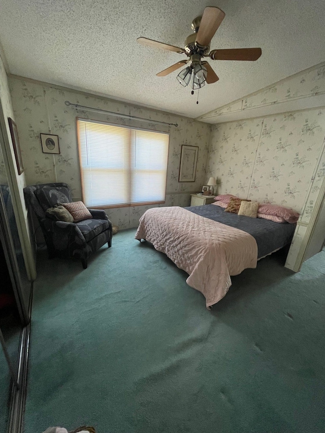 bedroom with a textured ceiling, carpet, a ceiling fan, and wallpapered walls