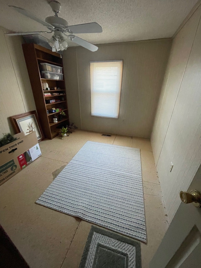 interior space with ceiling fan, visible vents, and a textured ceiling