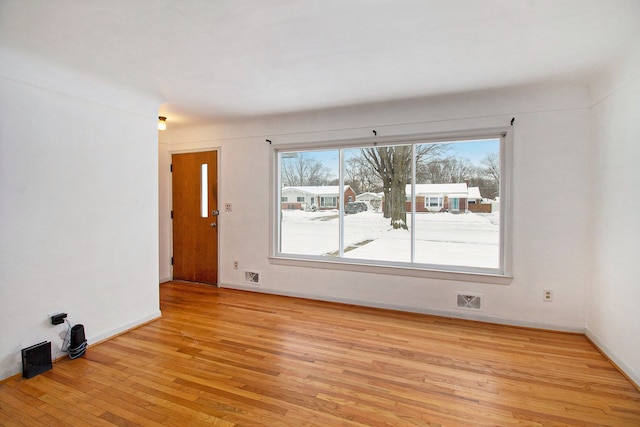 spare room with light wood-type flooring and baseboards