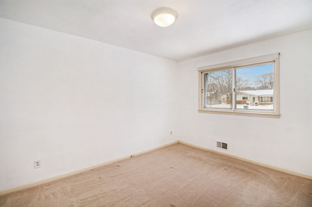 carpeted spare room with visible vents and baseboards