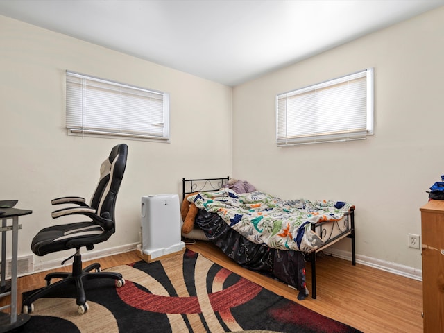 bedroom with visible vents, light wood-style flooring, and baseboards