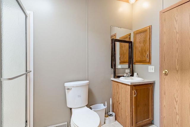 full bathroom with a shower with shower door, vanity, and toilet