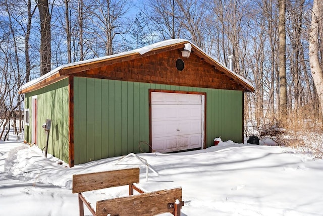 snow covered garage featuring a detached garage