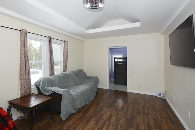 sitting room featuring lofted ceiling, a raised ceiling, baseboards, and dark wood-style flooring