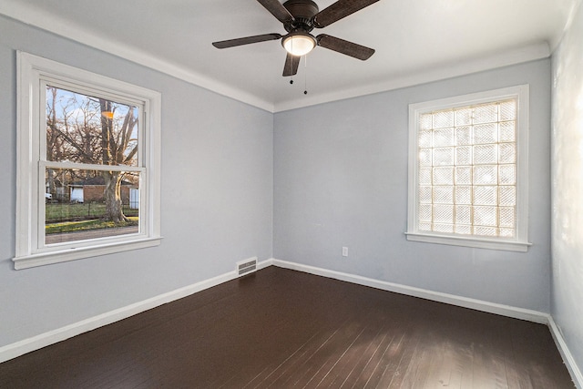 empty room with a ceiling fan, dark wood-style flooring, visible vents, and baseboards