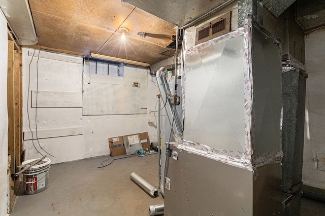 unfinished basement featuring visible vents and heating unit