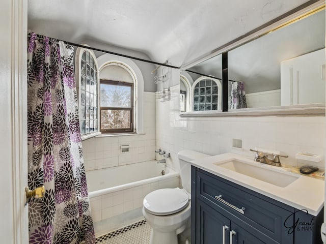 full bath with tiled shower / bath, tile walls, toilet, vanity, and tile patterned floors