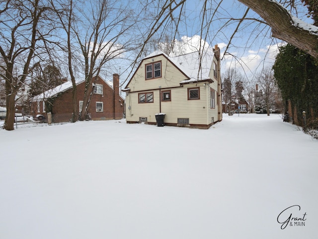 snow covered property with a chimney