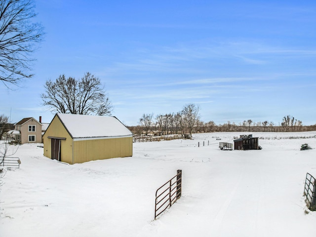 yard covered in snow featuring a detached garage