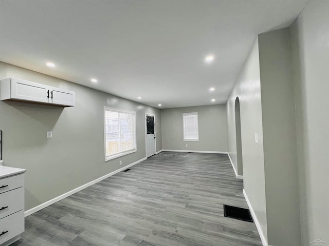 unfurnished living room with recessed lighting, baseboards, and light wood finished floors