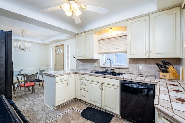 kitchen featuring tile countertops, black appliances, a peninsula, and a sink