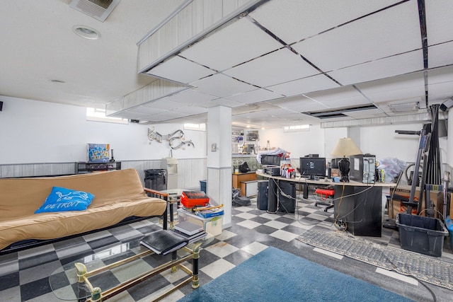 basement with a paneled ceiling, visible vents, and tile patterned floors