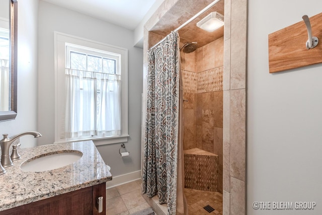 bathroom with baseboards, a shower stall, vanity, and tile patterned floors