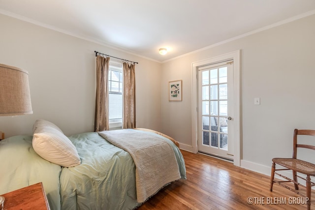 bedroom with baseboards, ornamental molding, and wood finished floors