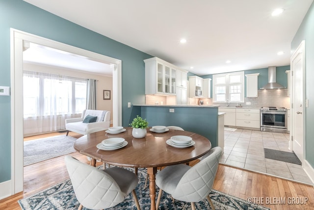 dining space with light wood finished floors, baseboards, and recessed lighting