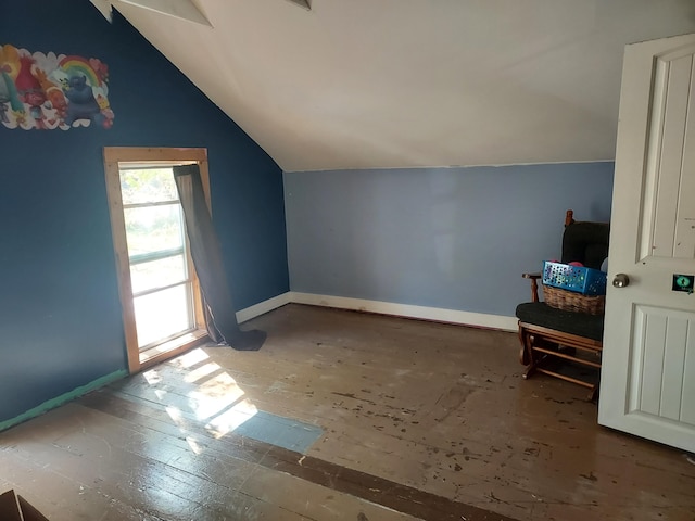 additional living space with baseboards and vaulted ceiling