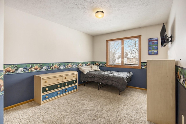 bedroom featuring baseboards, a textured ceiling, and light colored carpet