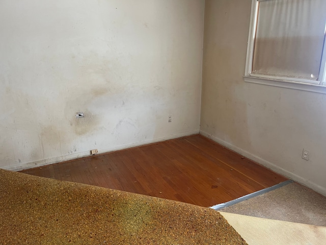 unfurnished room with wood finished floors and baseboards