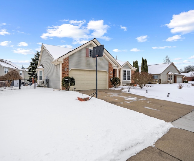 view of front of home featuring driveway, a residential view, an attached garage, fence, and brick siding