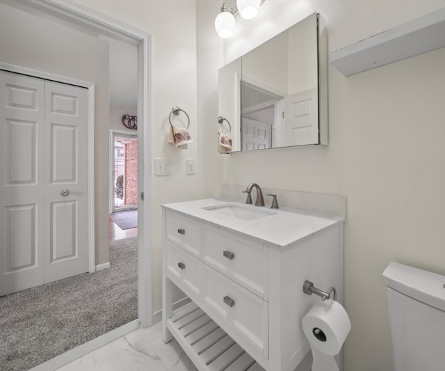 bathroom featuring toilet, marble finish floor, a closet, and vanity