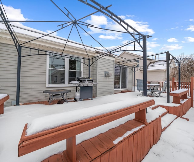 snow covered deck featuring grilling area and fence