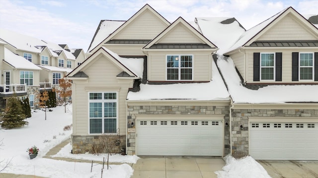 view of front of home with metal roof, an attached garage, concrete driveway, stone siding, and a standing seam roof