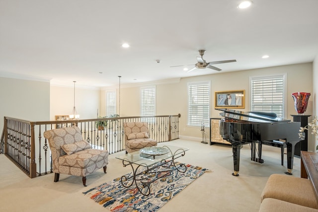 living area with light carpet, recessed lighting, baseboards, ornamental molding, and ceiling fan with notable chandelier