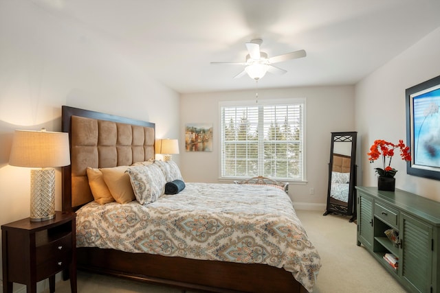 bedroom with ceiling fan, baseboards, and light colored carpet