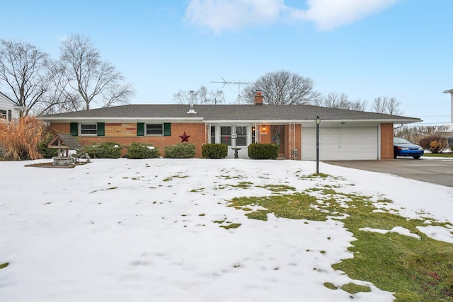 ranch-style house featuring a garage, brick siding, a chimney, and aphalt driveway