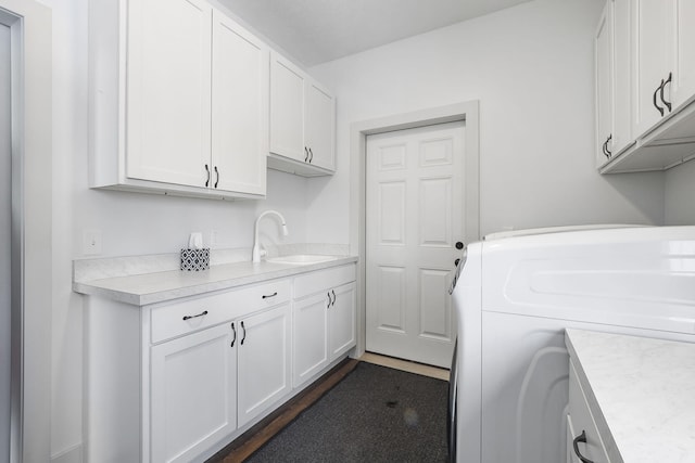 laundry area with cabinet space, a sink, and washer / dryer