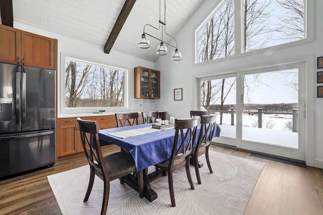 dining space featuring wood ceiling, beam ceiling, high vaulted ceiling, and wood finished floors