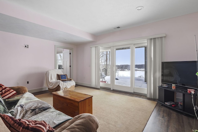 living area featuring dark wood-style floors, visible vents, and baseboards