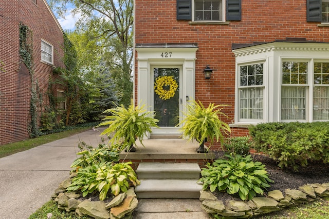 view of exterior entry featuring brick siding