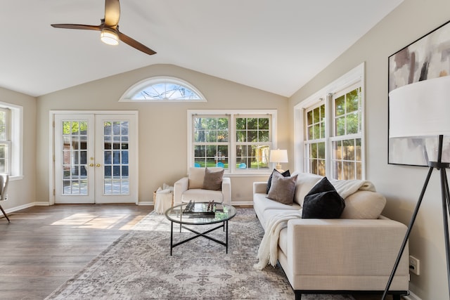 interior space featuring baseboards, ceiling fan, wood finished floors, vaulted ceiling, and french doors