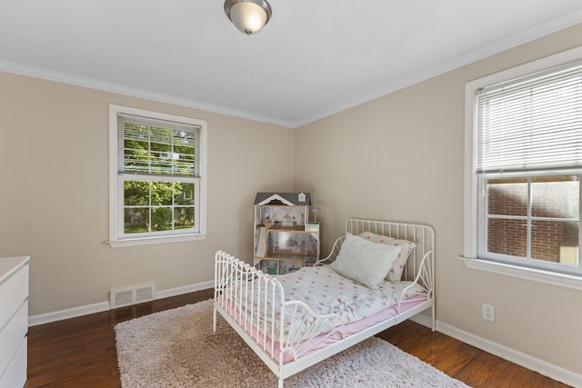 bedroom featuring dark wood-style floors, visible vents, crown molding, and baseboards