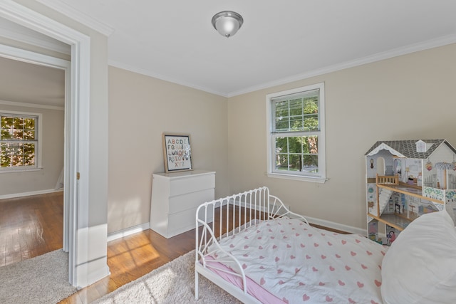 bedroom featuring ornamental molding, dark wood finished floors, and baseboards