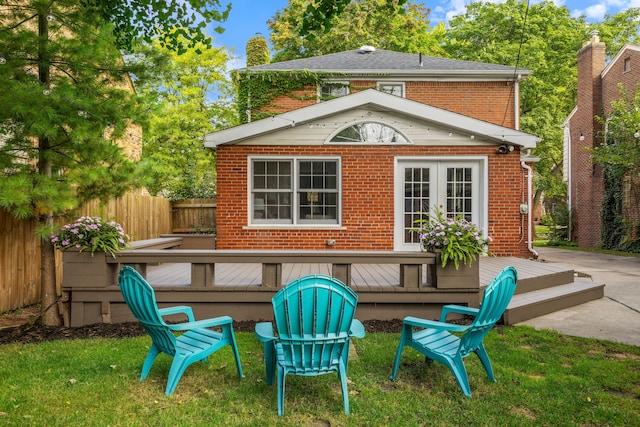 back of house with french doors, brick siding, a wooden deck, and fence