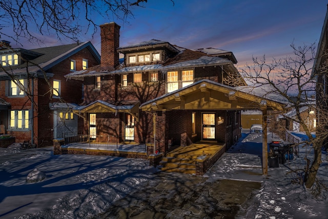 view of front of house featuring brick siding and a chimney