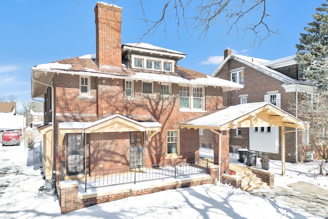 view of front of home featuring brick siding and a chimney