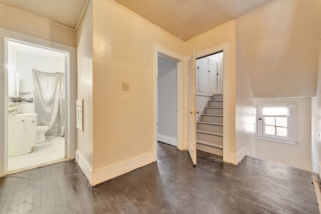 corridor featuring dark wood-style floors, stairs, and baseboards