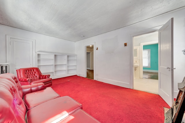 carpeted living area with baseboards and a textured ceiling