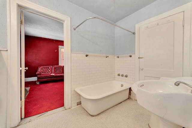 full bathroom with a sink, a soaking tub, ensuite bath, and tile walls