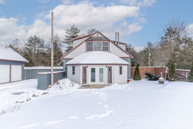 snow covered back of property with french doors