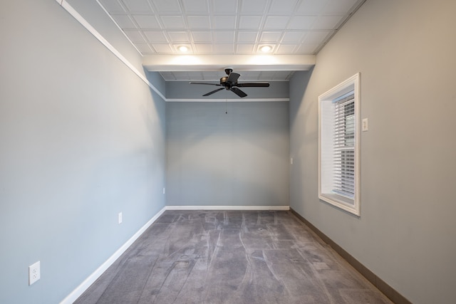 carpeted spare room with a ceiling fan and baseboards