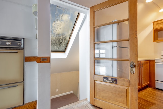 interior space with a skylight and light wood-style flooring