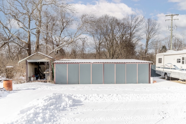 yard layered in snow with an outbuilding