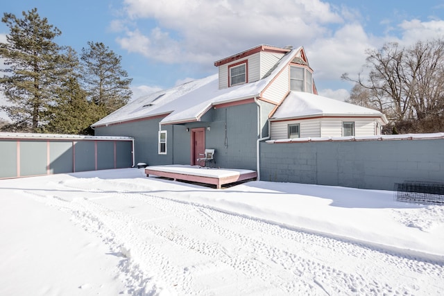 snow covered house with fence